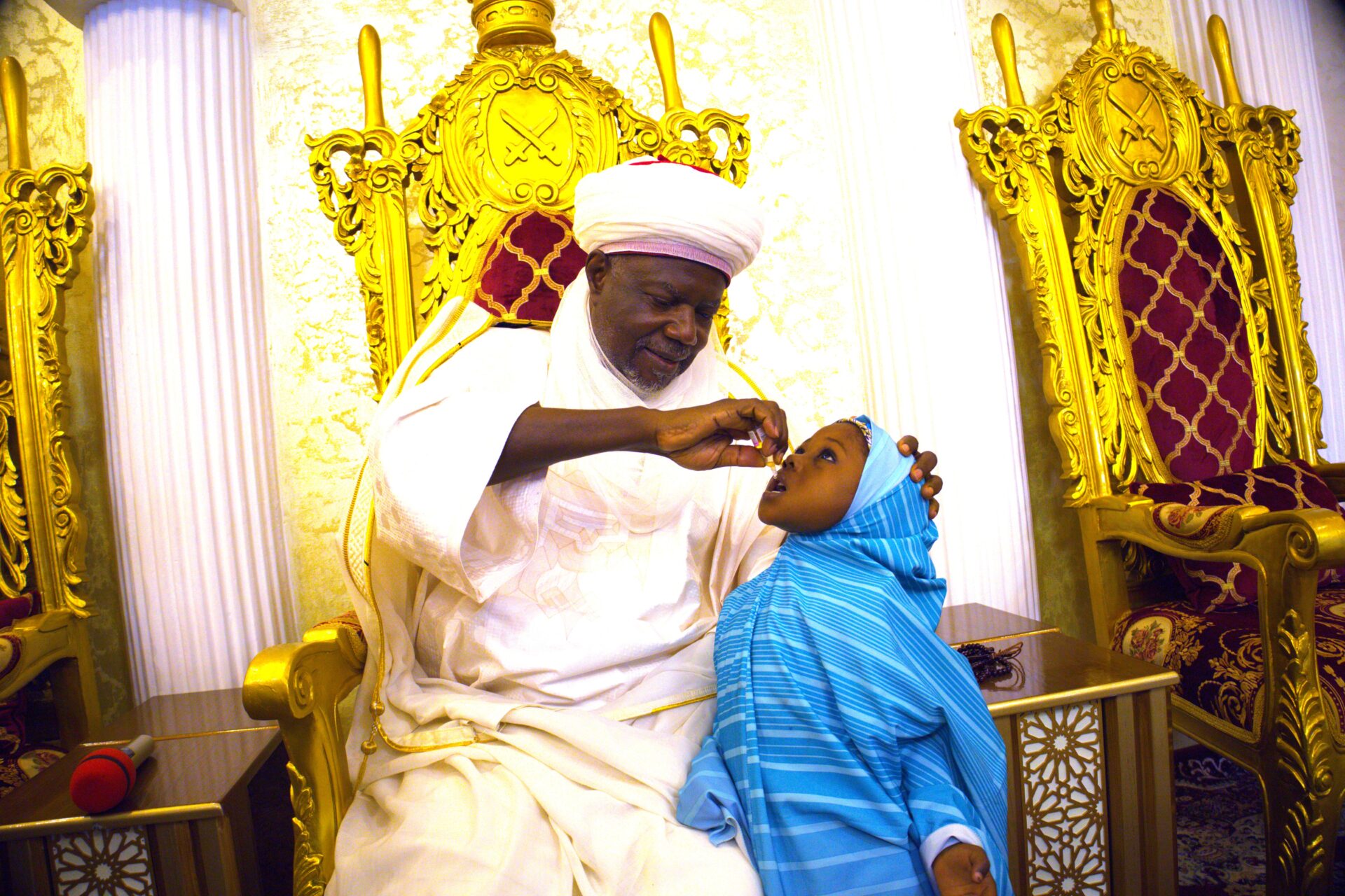 Emir of Argungu vaccinating his grand daughter